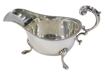Lot 303 - A George VI silver sauce boat, with a...