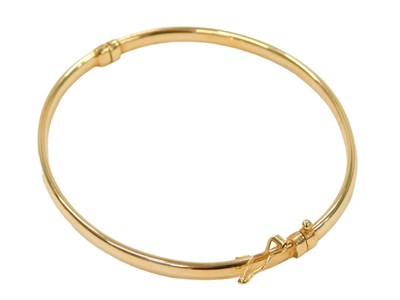 Lot 423 - A half hinged bangle, of plain design, yellow...