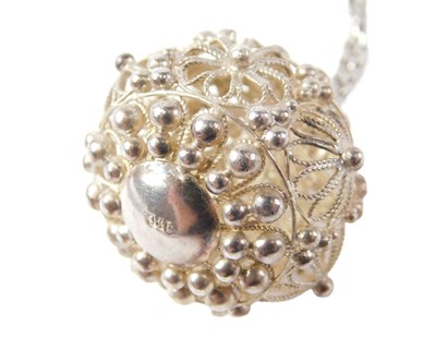 Lot 560 - An Eastern filigree ball pendant, white metal...