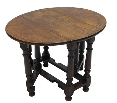Lot 991 - A oak oval dropleaf coffee table, on turned...