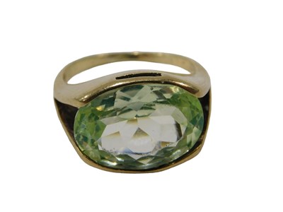 Lot 52 - A peridot dress ring, the oval peridot in...