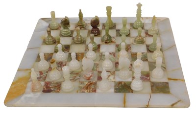 Lot 128 - A white and green onyx chess board and chess...