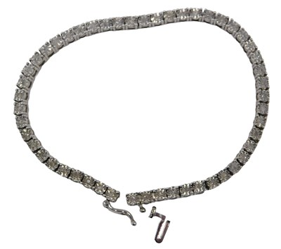 Lot 59 - A diamond tennis bracelet, set with illusion...