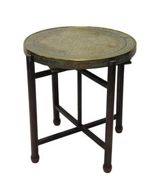 Lot 673 - An Indian brass tray table, the circular top...