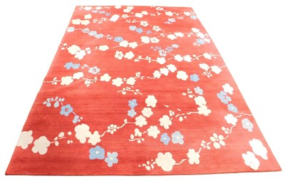 Lot 405 - A European red ground rug, decorated in pale...