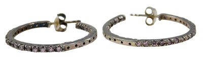 Lot 355 - A pair of silver and CZ hoop earrings, the...