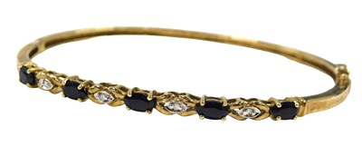 Lot 49 - A sapphire and diamond half hinged bangle, set...